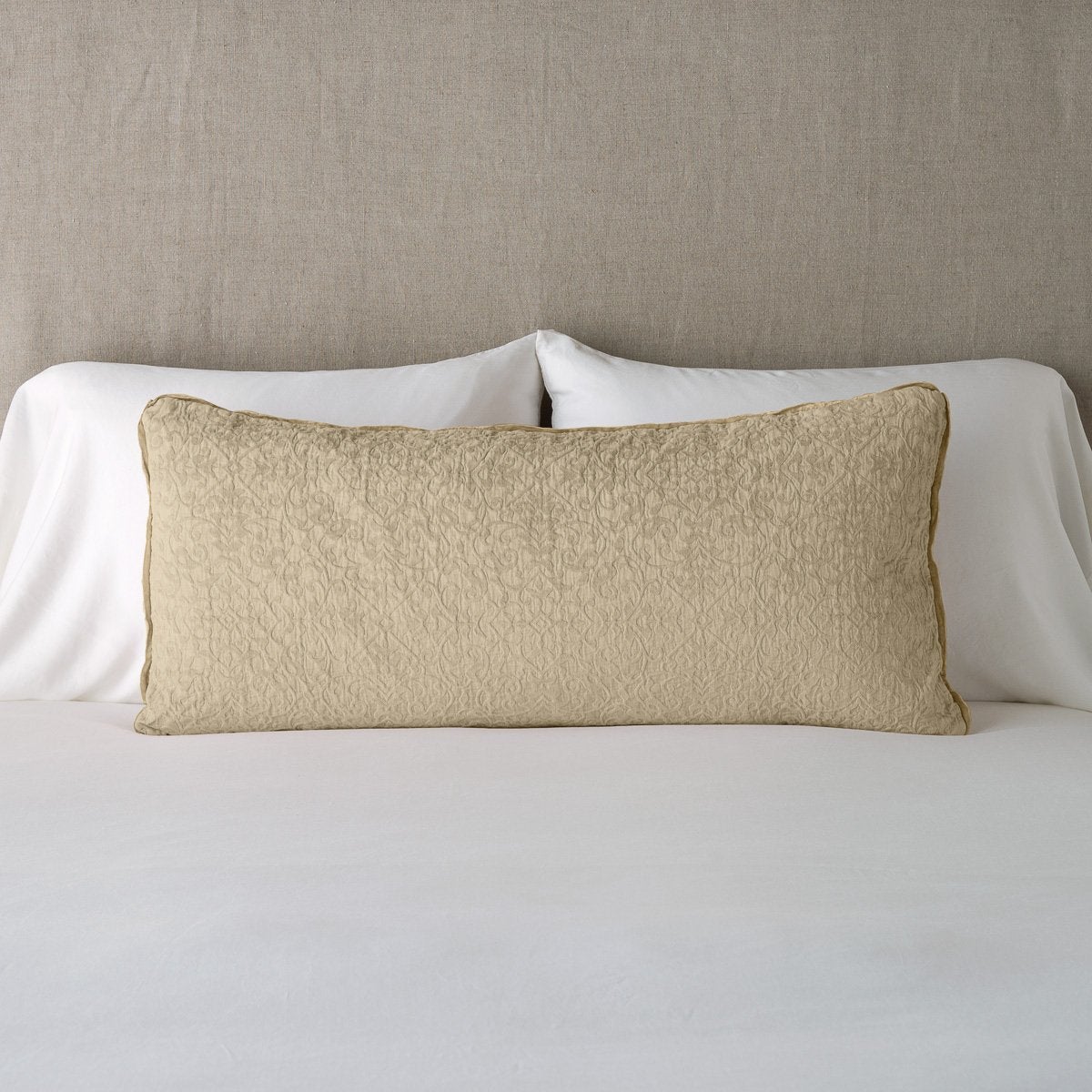 Honeycomb: 16x36 pillow leaning upright against white sleeping pillows on a neutral headboard.